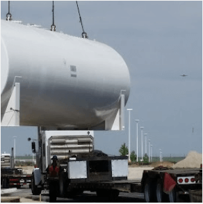 Cylindrical tank being craned into flat bed